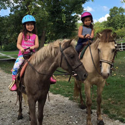 Two children each on their own horse.