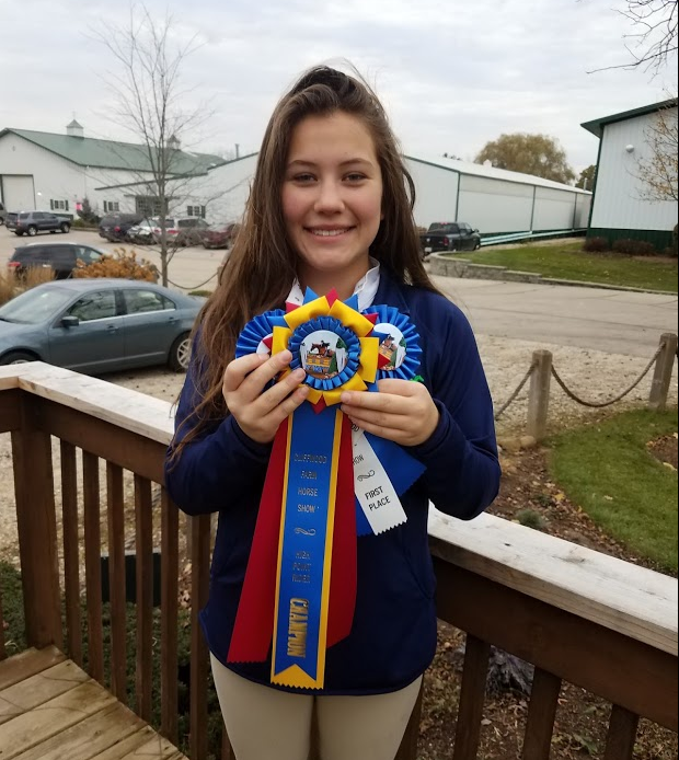 A young lady holding three ribbons.