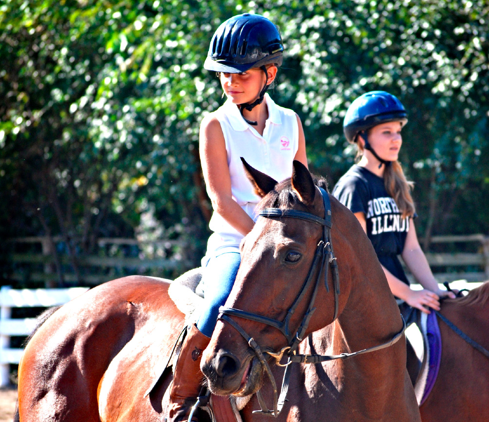 Two girls riding horses.