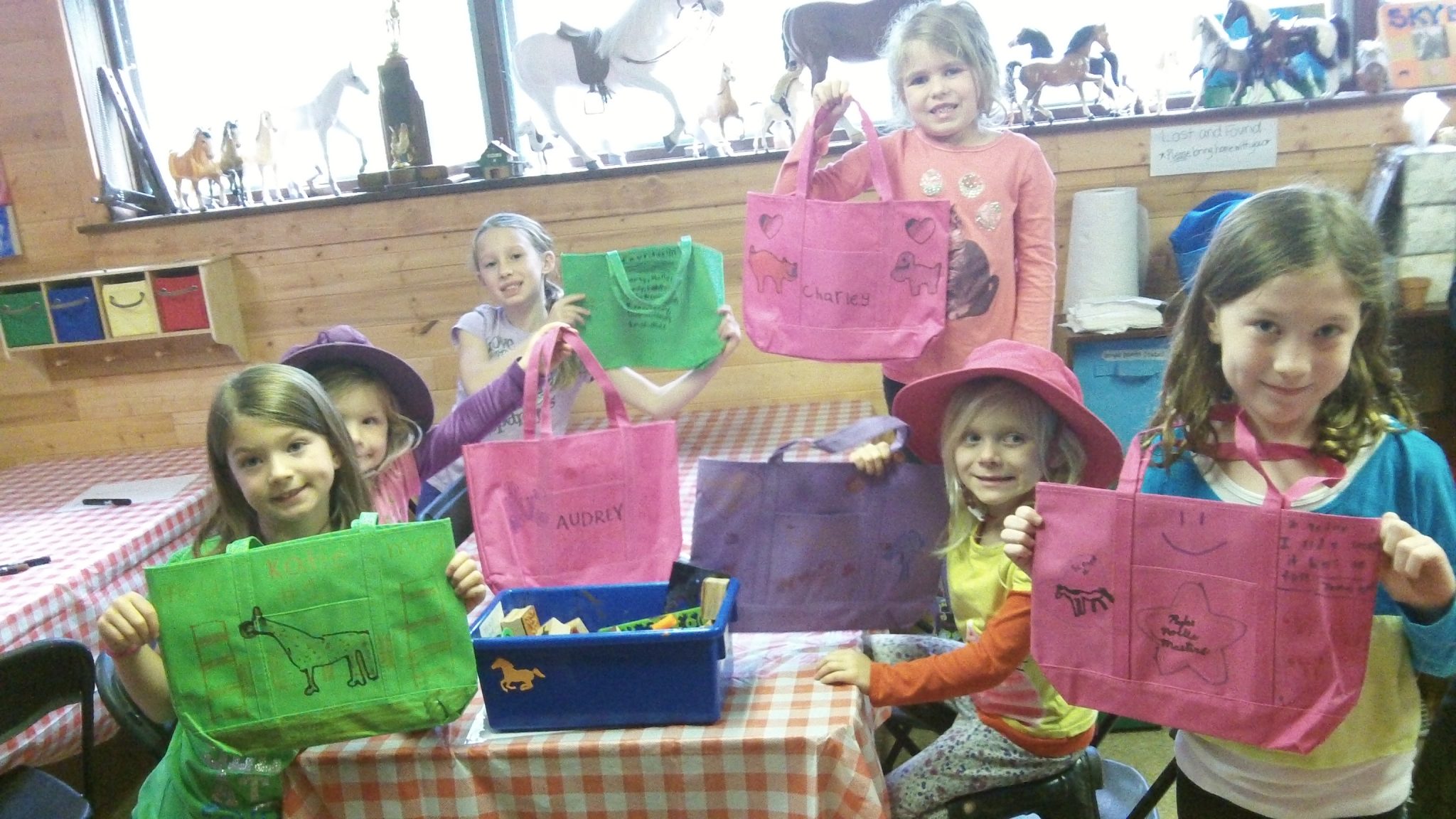 Kids holding up decorated bags.