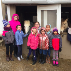 Group photo of children with a few horses