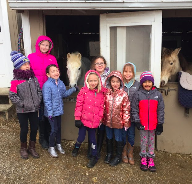 Group photo of children with a few horses