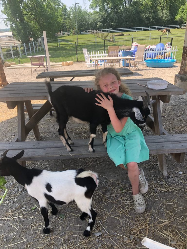Girl Hugging Goats